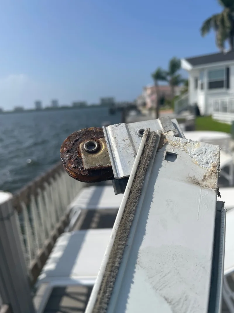 Worn sliding door roller being examined during a repair cost assessment