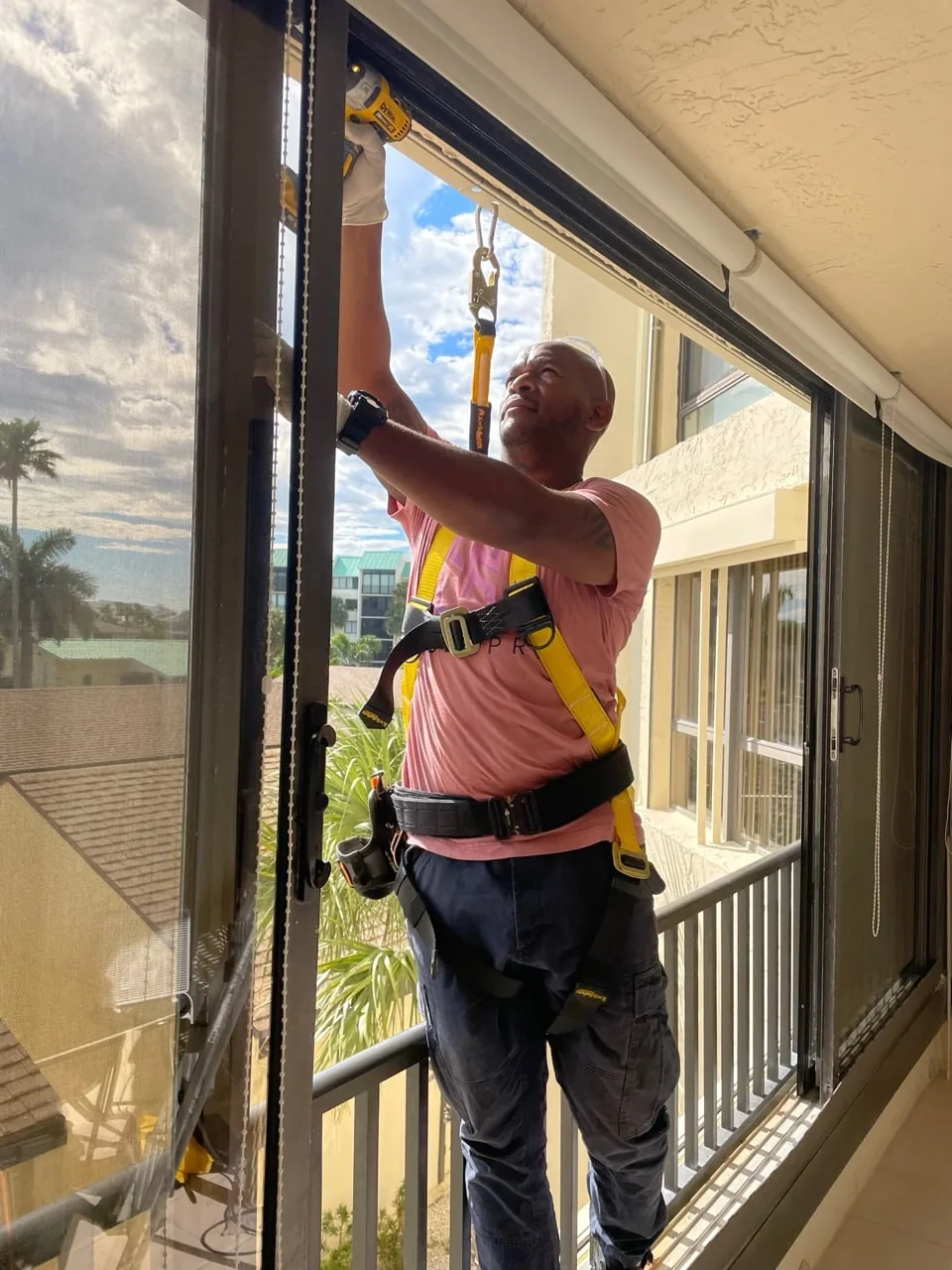 SliderPro technician working on an elevated sliding door panel at a Jupiter property