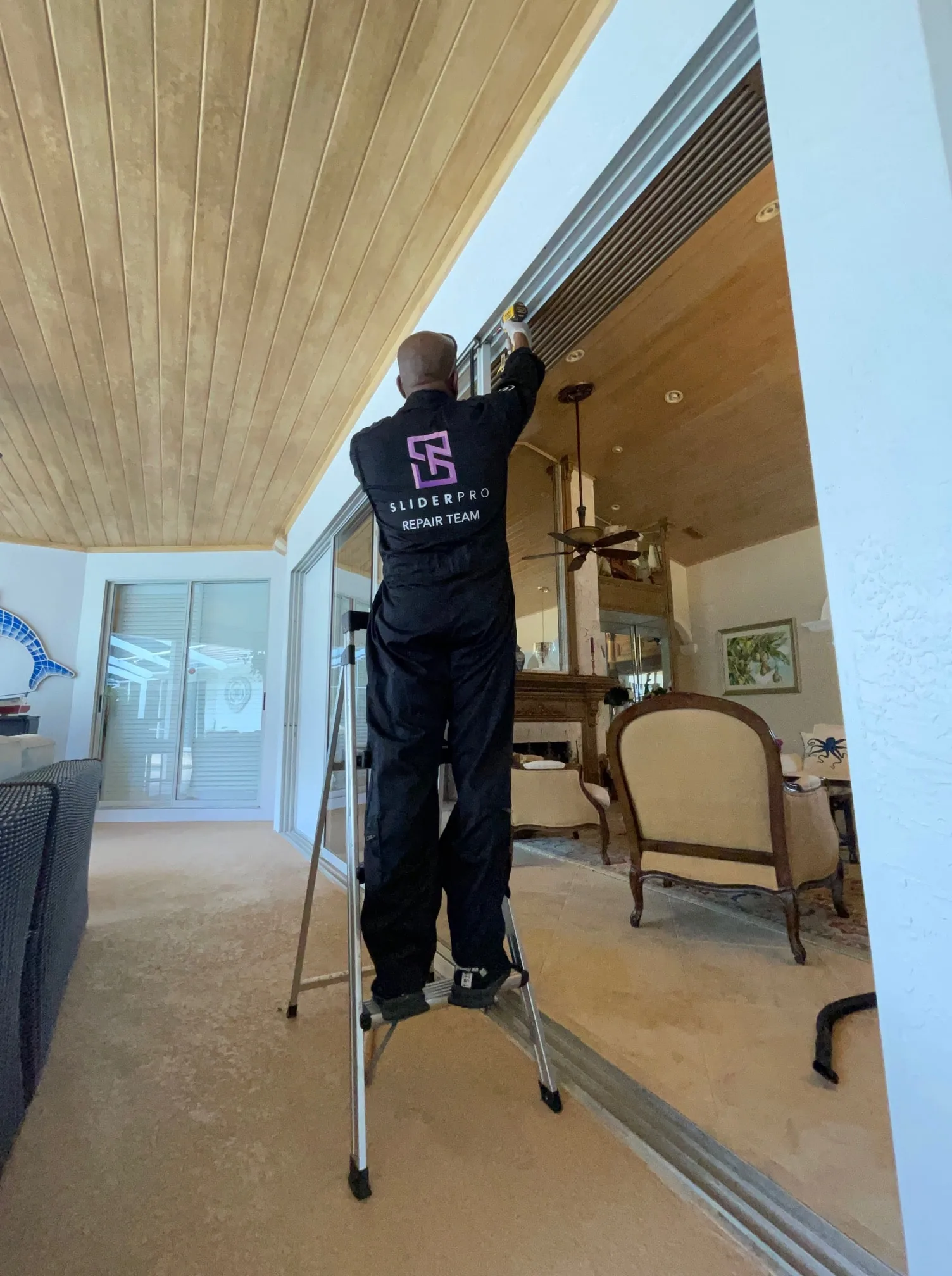 SliderPro technician servicing a lanai sliding door in a Palm City golf community home