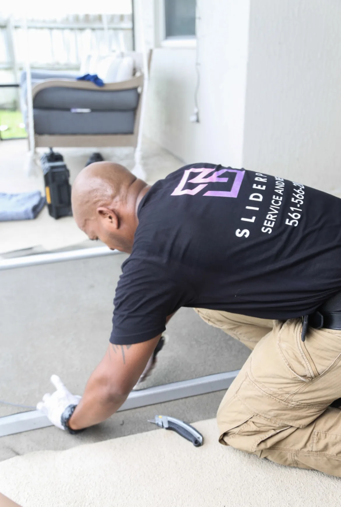 Technician demonstrating proper sliding door track cleaning technique
