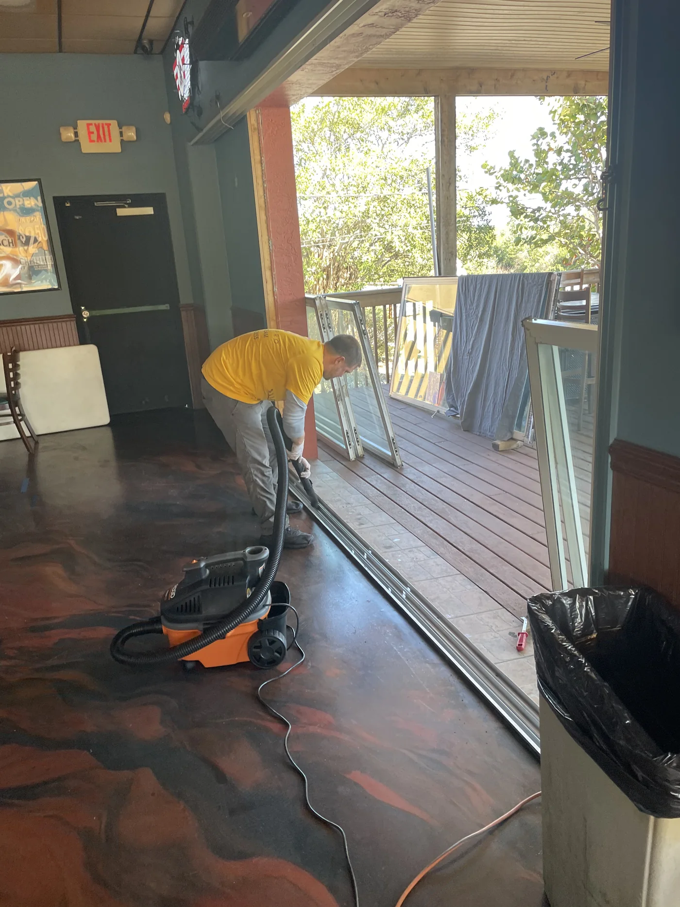 SliderPro technician vacuuming debris out of a sliding door track with the panel lifted out