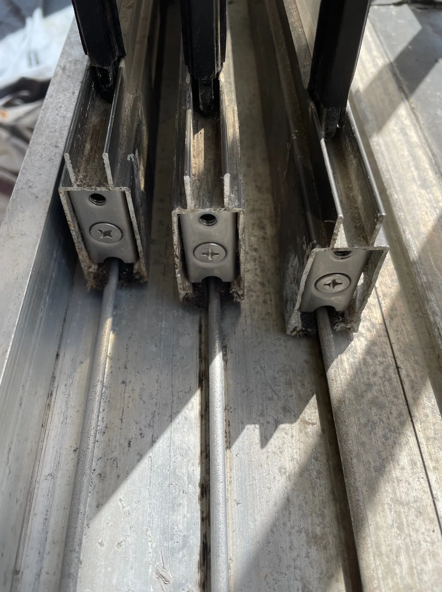 Close-up of worn sliding door rollers on their track rails