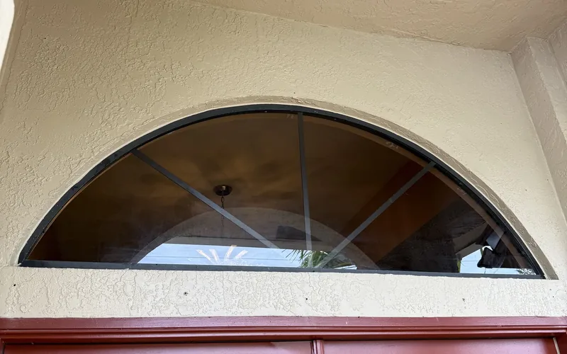 Replaced half-round arched window glass fitted in its original frame