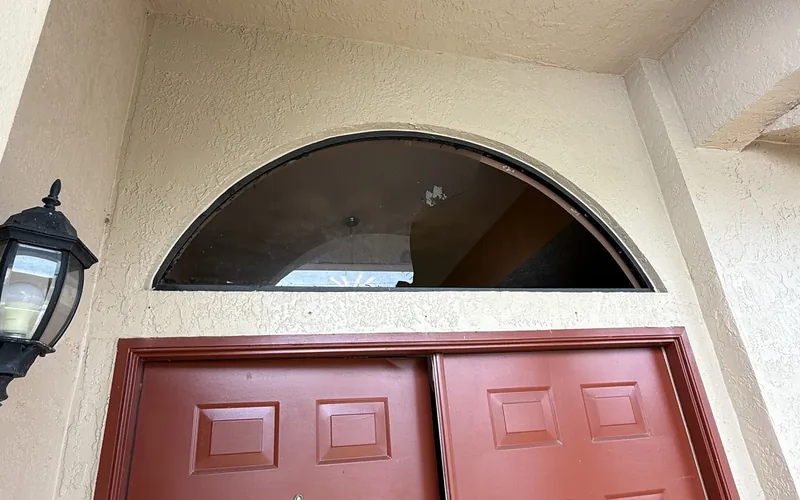 Cracked half-round arched window before replacement