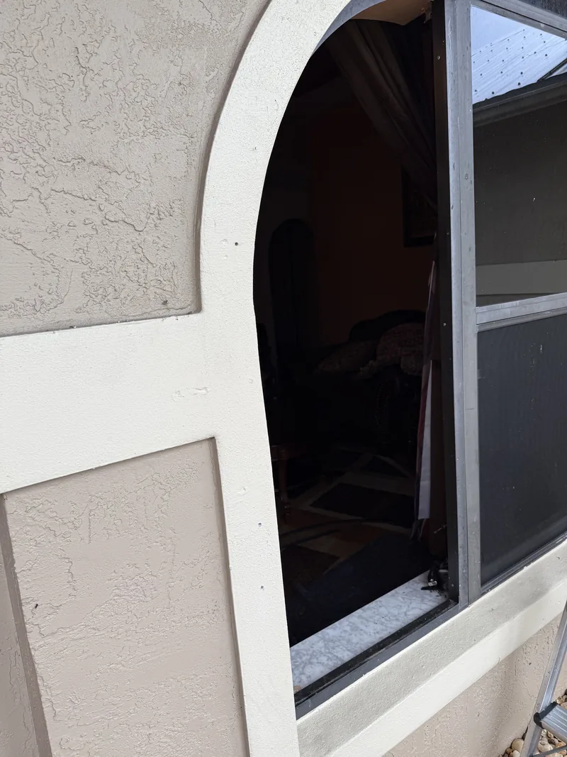 Arched window opening with the glazing removed, looking through into the interior of the home