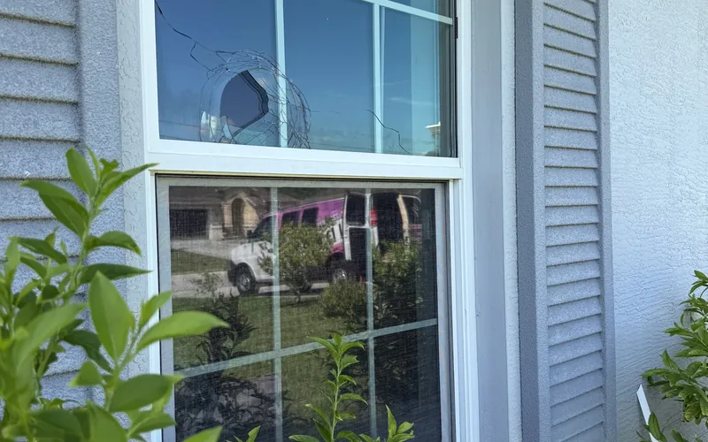 Struck impact window holding together with the glass cracked in place